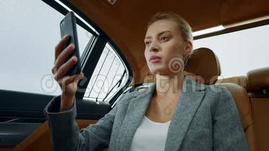 漂亮的女商人在车上打视频电话。 <strong>专注</strong>的女人摸脸